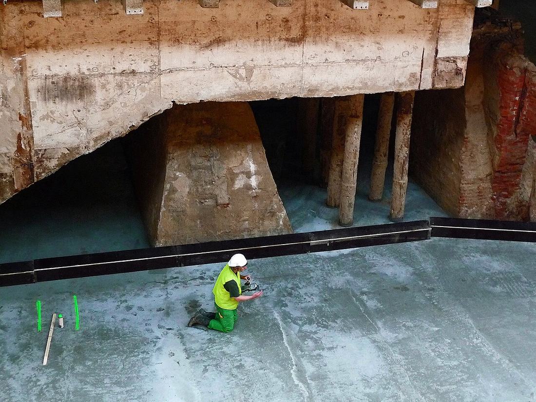 A construction worker is working underground during the renovation of Central station Amsterdam; free photo Amsterdam by Fons Heijnsbroek, 2012